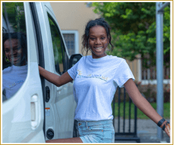 CEO Sierra getting out of a white guide van in Ghana and smiling at the camera